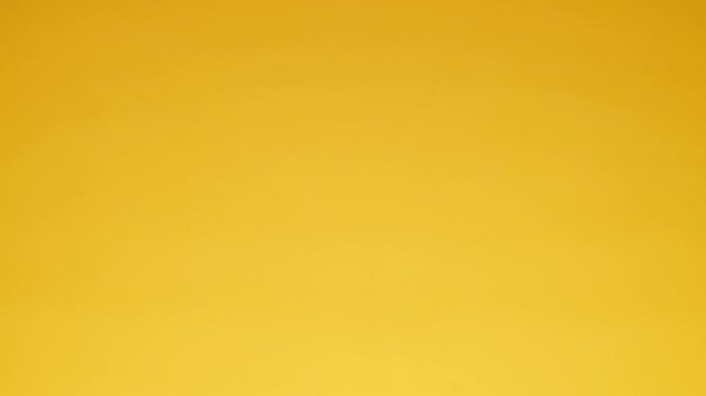 Golden colored Water Drops falling into the water producing waves and ripple effects. Molten gold effect. Slow motion footage 100fps.