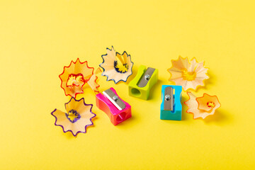 Obraz premium Pencil sharpener on bright colored background. Pencil and pencil shavings. Stationery. School supplies. School products. Flat lay. Place for text. copy space.