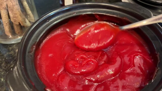scoop ketchup with a spoon hand stirs fish soup with a tablespoon in a white plate with wide sides and places a piece of grilled bread on it. Vertical video. High quality 4k footage