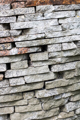 A beautifully textured granite stone wall featuring a unique layered design