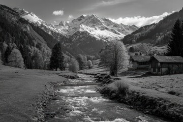 Obraz premium Tranquil Alpine Valley: Snow-Capped Peaks Surrounding a Pristine River Through Green Meadows and a Quaint Chalet black and white