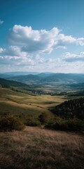 Scenic mountain valley landscape with rolling hills and blue sky