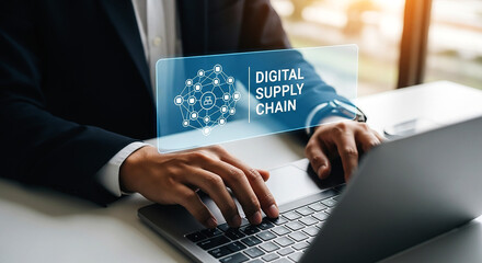 Man typing on laptop with digital supply chain graphic overlay and wearing a suit and a watch