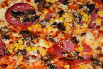 Close-up view of a delicious pizza topped with pepperoni, mushrooms, and corn. Perfect for food-related content or culinary showcases.