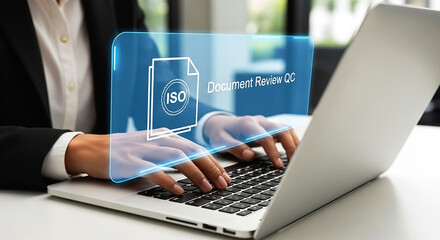 Person typing on laptop with iso document review qc graphic overlaying the screen in a business setting