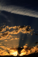 Dramatic sky scene with sun rays breaking through clouds