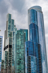 Obraz premium City architecture. Modern glass building. Reflective glass architecture. Architecture in business district. Building architecture. Business building. Glass building. Business city. Office center