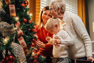 Happy family decorating christmas tree together at home