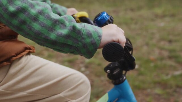 Close side shot of boy gripping bicycle handlebar while cycling forest path Symbol of focus independence and natural digital detox. High quality 4k footage