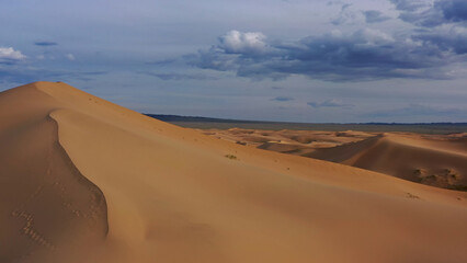 Aerial view of sand dunes in desert at sunset