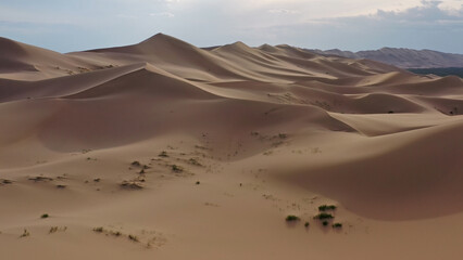 Aerial view of sand dunes in desert at sunset