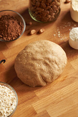 Ball of raw dough made of whey protein powder, ground oat flakes, maple syrup and nut butter - preparation of homemade bars