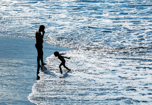 Tourists enjoying the waves and the volcanic sand on the wild Benijo beach, located on the north of Tenerife Island near the Roques de Anaga, Canary Archipelago, Spain, Europe	