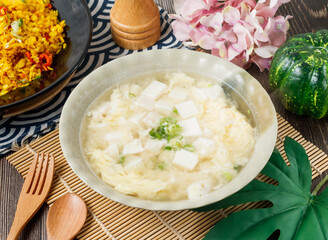 Comforting Egg Drop Tofu Soup with silken tofu and spring onions in bowl side view of hong kong food