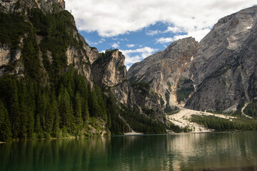 Photography of Lago di Braies, Italy, showing the turquoise alpine lake surrounded by mountains, pine forests, and scenic natural landscape in the Dolomites.