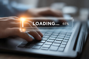 Close-up of hands typing on laptop keyboard with futuristic digital loading progress bar indicating 65 percent during software or data upload process