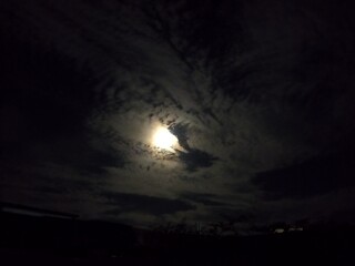 Naklejka premium Full Moon Shining Through Dark Night Clouds