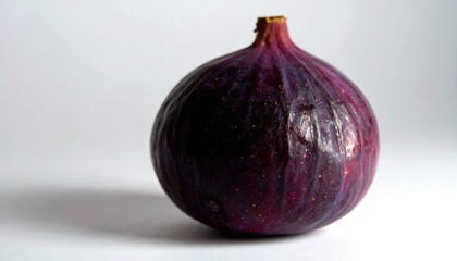 Close-up of a deep purple fig.  Its smooth skin has subtle texture