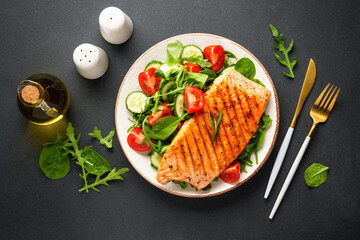 Fish salad. Healthy food, keto diet plate on black background.