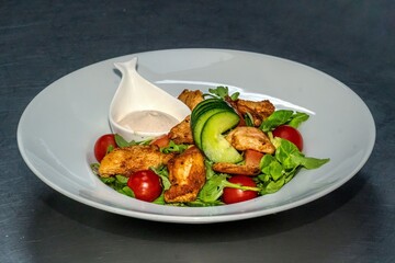Chicken salad with vegetables and sauce on plate