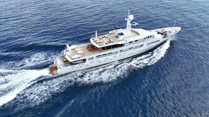 Fototapeta premium Aerial drone tracking photo of super yacht with wooden deck cruising deep blue Aegean Sea