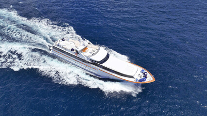 Fototapeta premium Aerial drone tracking photo of super yacht with wooden deck cruising deep blue Aegean Sea