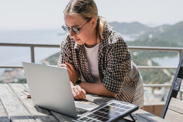 digital nomad woman working remotely from a cozy kitchen during breakfast. Remote work,...