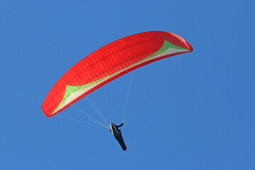 Paraglider flying in a blue sky	