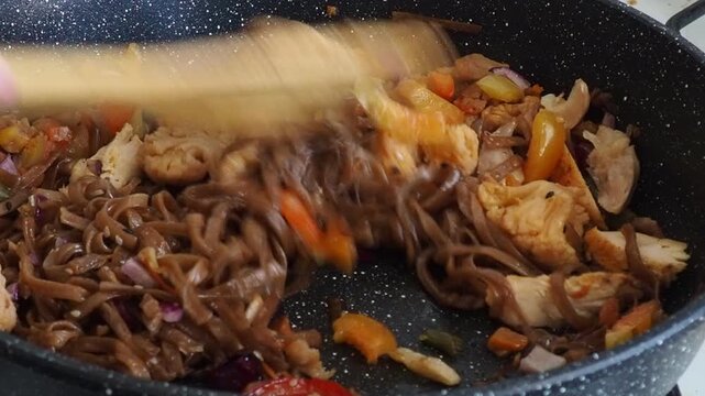 Schezwan Noodles or Vegetable Hakka Noodles or Chow Mein in white bowl. Schezwan Noodles is indo-chinese cuisine hot dish with udon noodles, vegetables and chilli sauce with meat, Japanese food