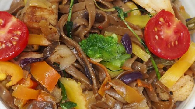 Schezwan Noodles or Vegetable Hakka Noodles or Chow Mein in white bowl. Schezwan Noodles is indo-chinese cuisine hot dish with udon noodles, vegetables and chilli sauce with meat, Japanese food