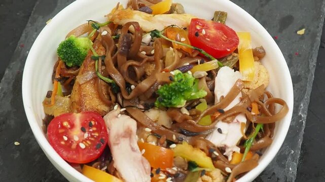 Schezwan Noodles or Vegetable Hakka Noodles or Chow Mein in white bowl. Schezwan Noodles is indo chinese cuisine hot dish with udon noodles, vegetables and chilli sauce with meat, Japanese food
