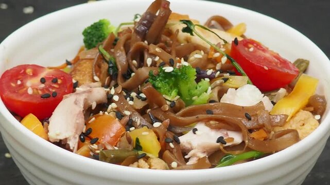 Schezwan Noodles or Vegetable Hakka Noodles or Chow Mein in white bowl. Schezwan Noodles is indo chinese cuisine hot dish with udon noodles, vegetables and chilli sauce with meat, Japanese food