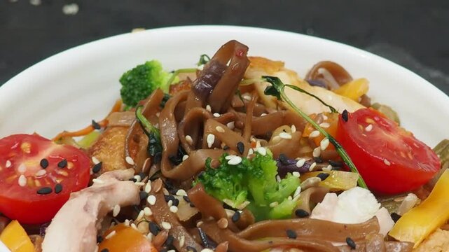 Schezwan Noodles or Vegetable Hakka Noodles or Chow Mein in white bowl. Schezwan Noodles is indo chinese cuisine hot dish with udon noodles, vegetables and chilli sauce with meat, Japanese food
