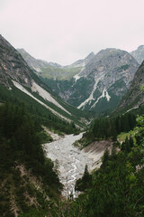 Alpental mit Wildbach und steilen Felsflanken in den Nordalpen