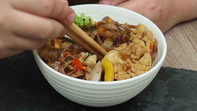 Schezwan Noodles or Vegetable Hakka Noodles or Chow Mein in white bowl. Schezwan Noodles is indo-chinese cuisine hot dish with udon noodles, vegetables and chilli sauce with meat, Japanese food