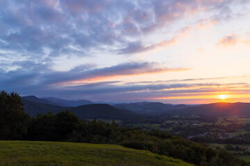 Colorful sunset illuminating rolling hills and valleys