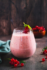 Antioxidant smoothie with red currant in a glass on the table vertical view
