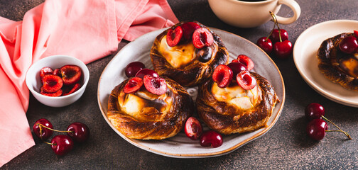 Fluffy buns with cottage cheese and cherries on a plate on the table web banner
