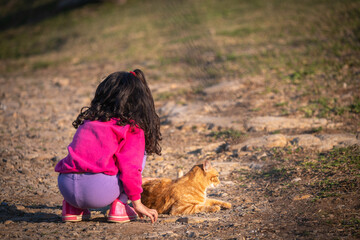 little girl playing with cat