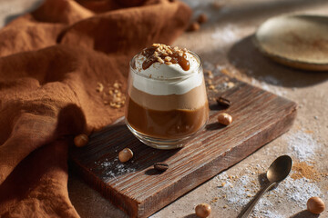 Layered coffee dessert — smooth mousse, fluffy cream, and caramel layer with nuts. Cozy rustic composition with natural daylight