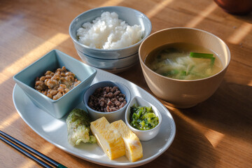 Traditional Japanese breakfast with rice, miso soup, natto, and side dishes
