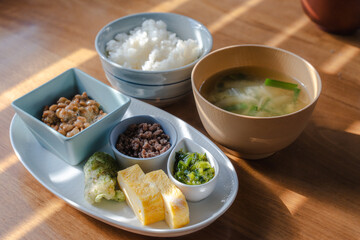 Traditional Japanese breakfast with rice, miso soup, natto, and side dishes

