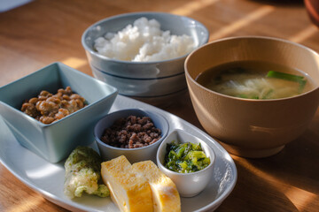 Traditional Japanese breakfast with rice, miso soup, natto, and side dishes
