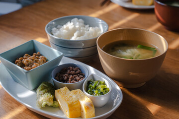 Traditional Japanese breakfast with rice, miso soup, natto, and side dishes
