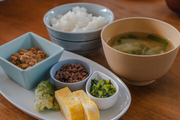 Traditional Japanese breakfast with rice, miso soup, natto, and side dishes
