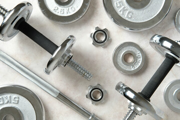 Chrome dumbbells and weight plates arranged on light surface. Essential gym gear for strength...