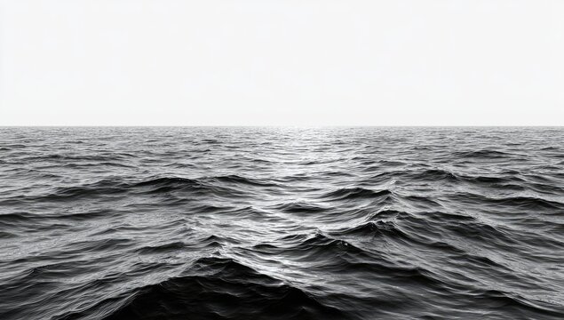 Gray monochrome view of ocean waves.  Horizon line is visible