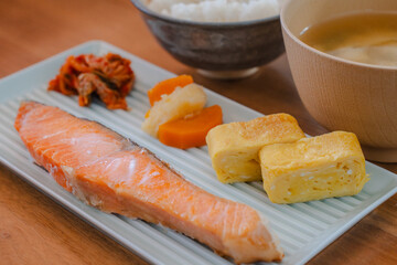 Traditional Japanese breakfast with grilled salmon, tamagoyaki, rice, and miso soup
