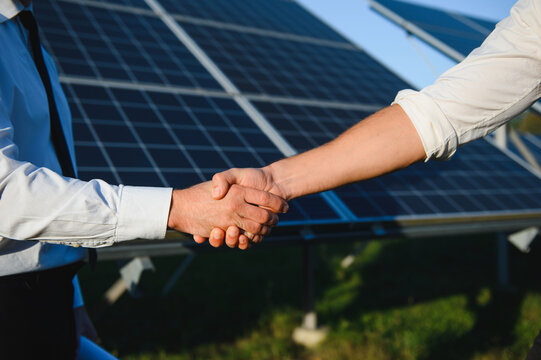 Close up of Two Electrical Engineers shaking hands after working to inspect the installation and maintenance of solar panels in the solar power station
