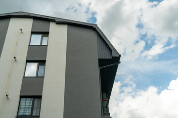 Modern residential building with angular design against a bright sky in a suburban neighborhood